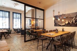 ein Restaurant mit Tischen und Stühlen und einem Gemälde an der Wand in der Unterkunft Hotel Julien in ’s-Hertogenbosch