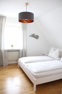 um quarto com uma cama branca e uma grande janela em Strandhütte em Norddeich