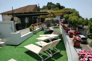 a patio with tables and chairs on the grass at Hotel Parsifal - Antico Convento del 1288 in Ravello
