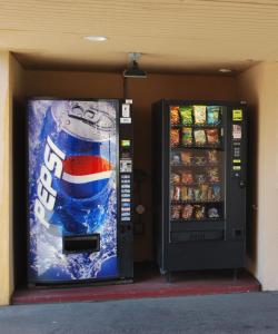 una máquina de refrescos y una máquina expendedora de refrescos en South Bay Motel en Copiague