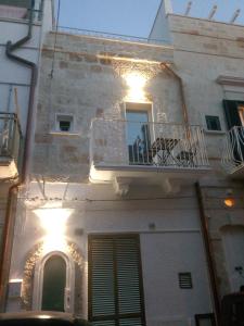 ein weißes Gebäude mit einem Balkon und einem Fenster in der Unterkunft Romi' in Polignano a Mare