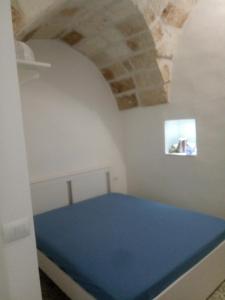 ein Schlafzimmer mit einem blauen Bett in einem Zimmer in der Unterkunft Romi' in Polignano a Mare