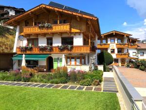 a large house with a balcony and a yard at Aparthotel Krösbacher in Fulpmes