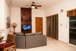 a living room with a couch and a ceiling fan at Las Olas Condominium #207 in Playa del Carmen