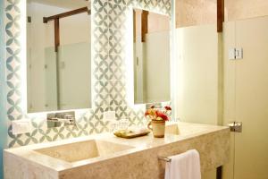 a bathroom with a shower, sink, and mirror at Villas Caracol in Holbox Island