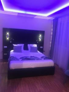 1 dormitorio con 1 cama grande con iluminación púrpura en chambre suite B&B en Montpellier