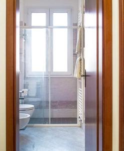 a bathroom with a shower and a toilet and a window at casa dei nonni in Murano