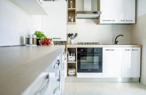 a kitchen with white cabinets and an oven at casa dei nonni in Murano