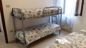 2 stapelbedden in een kamer met een tafel bij casa dei nonni in Murano