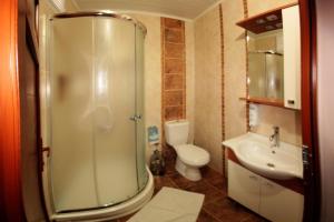 a bathroom with a shower and a toilet and a sink at Boomerang Guest House in Selçuk