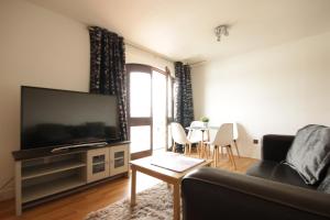 a living room with a couch and a flat screen tv at Marina Humber View Apartment in Hull
