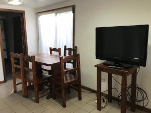 a living room with a television and a table with chairs at chula"s house in Ushuaia