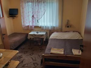 フミエルノにあるPokoje gościnne u Jasia i Małgosi w Chmielnie na Kaszubachのベッド2台と窓が備わる小さな客室です。