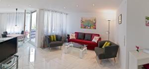 a living room with a red couch and chairs at Loft Orchidee in Überlingen