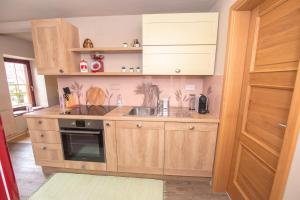 a kitchen with wooden cabinets and a sink at House Bovecation in Bovec