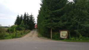 a dirt road with a sign on the side of the road at Agroturystyka pod Czarną Sosną in Biały Ług