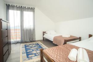 ein Schlafzimmer mit zwei Betten und einem Fenster in der Unterkunft GardenLux Sarajevo in Sarajevo + 35 Fotos