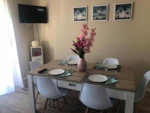 une table à manger avec des chaises et un vase de fleurs dans l'établissement Monteur Apartment Rodenbach, à Rodenbach
