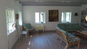 a living room with green couches and chairs at BILLE's HUS in Tisvildeleje