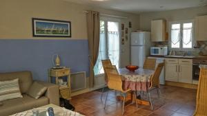 a kitchen and living room with a table and a couch at villa OLERON in Chaucre