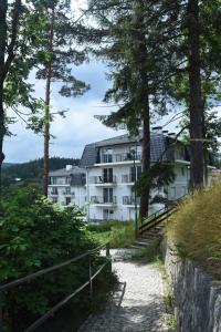 a white building in the middle of trees at Apartamenty Magnum in Szklarska Poręba