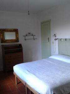 una camera con letto, cassettiera e specchio di La Rocca Chianti Hospitality a Tavarnelle in Val di Pesa