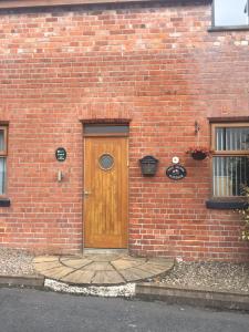 a brick building with a wooden door on it at Mews Cottage Bangor in Bangor