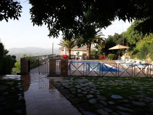 a swimming pool with a fence next to a house at Villa SABENA in Cazorla