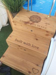 a wooden staircase with a sign that reads built with love at Dimore di Mare in San Pietro Vernotico