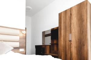 einen Holzschrank mit einem Spiegel im Schlafzimmer in der Unterkunft Hotel Castle Rastatt in Rastatt + 35 Fotos