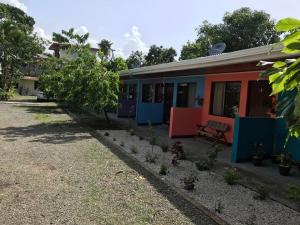 una casa colorata con una panchina davanti di Cabinas Surf Side a Cahuita