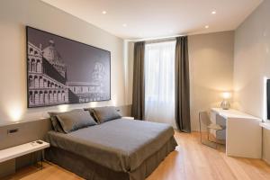 モンテヴァルキにあるPalazzo Vasarri - Luxury design suitesのベッドルーム1室(ベッド1台付)、壁に大きな絵画が備わります。