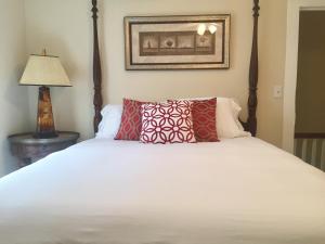 a bedroom with a white bed with red pillows at Villa Riberia in Saint Augustine