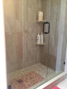 a shower with a glass shower stall with two shelves at Villa Riberia in St. Augustine
