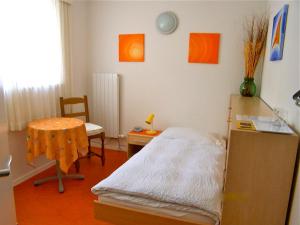 Kleines Zimmer mit einem Bett und einem Tisch in der Unterkunft Hotel Pizzo Vogorno in Vogorno