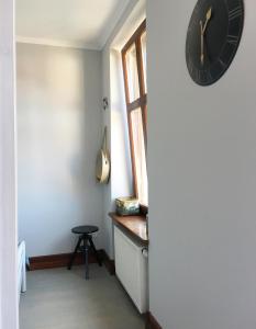 a clock on the wall of a room with a stool at L.D. SPA Apartment in Rewal