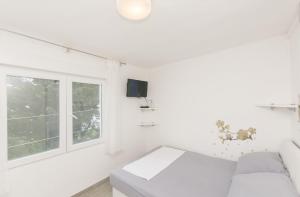 sala de estar blanca con sofá y ventana en House Anica, en Starigrad-Paklenica
