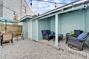un patio con sillas de mimbre, mesa y sombrilla en New Orleans Cottage en Nueva Orleans