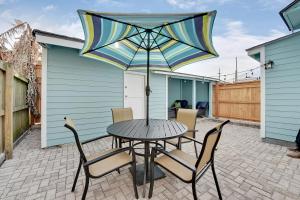 a table and chairs with an umbrella on a patio at New Orleans Cottage in New Orleans