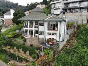 ein großes weißes Haus auf einem Hügel in der Unterkunft 36 Bed & Breakfast in Kandy