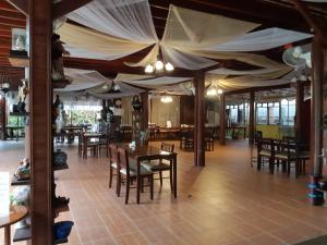a dining room with tables and chairs and a ceiling at Montri Resort Donmuang Bangkok in Bangkok