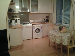 eine Küche mit einer Waschmaschine und einem Tisch in der Unterkunft Metro SAHIL Seaside Centr in Baku