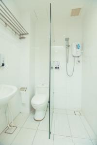 a white bathroom with a toilet and a shower at ExcluSuites Malacca @ The Wave Residence in Malacca
