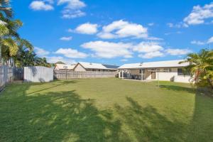 a large yard with a fence and a house at 3 bedroom home in Ross River