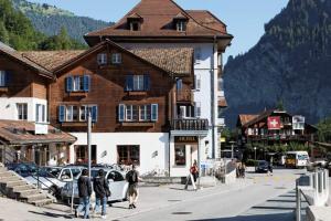 un grupo de personas caminando por una calle frente a un edificio en Ferienwohnung Bahnhöfli, en Lauterbrunnen