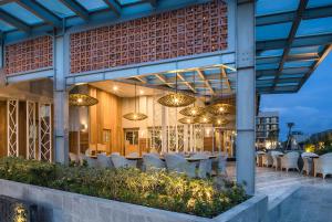 a restaurant with white chairs and tables on a patio at Eastin Ashta Resort Canggu in Canggu