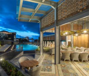 a restaurant with a view of the pool at night at Eastin Ashta Resort Canggu in Canggu