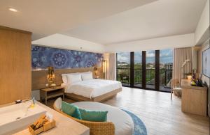 a bedroom with a bed and a bathroom with a tub at Eastin Ashta Resort Canggu in Canggu