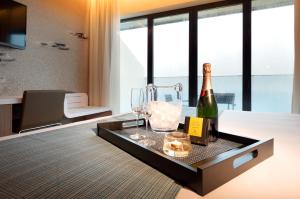 uma sala de estar com uma garrafa de vinho e um copo em Eurostars Cascais em Cascais mais 61 fotografias