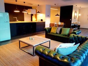 a living room with leather couches and a coffee table at Oduo Nature in Jalhay